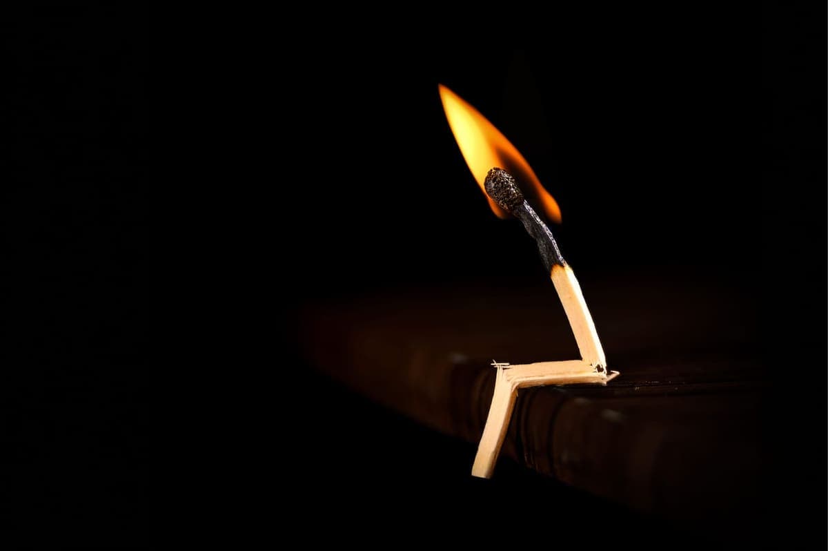 A match burning against a dark background